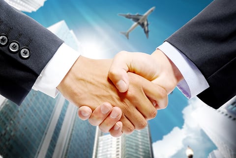 handshake with airplane in background