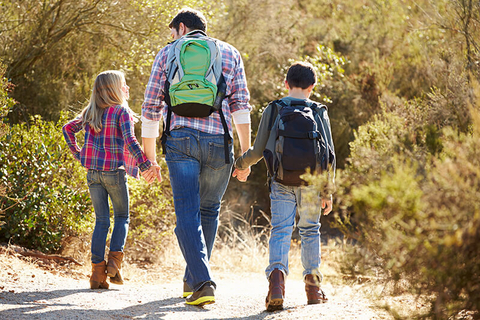 dad and children hiking // Photo by monkeybusinessimages/iStock/Getty Images Plus/Getty Images dad and children holding hands and hiking in the woods