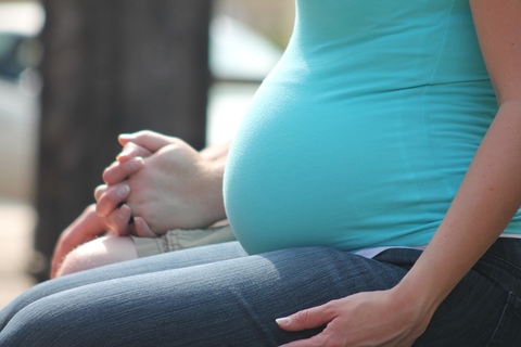 pregnant a pregnant woman wearing a blue shirt