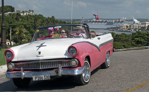 Carnival Paradise in Havana Cuba Editorial A classic car drives in Havana Cuba with Carnival Paradise in the background