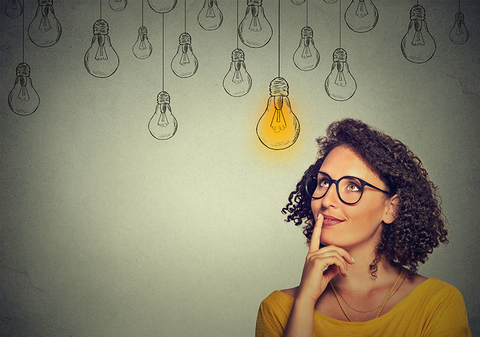 Woman Idea Inspiration Getty Woman in glasses looking up with light idea bulb