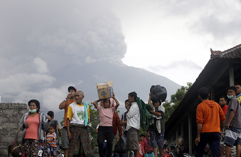 Bali Volcano Eruption Newscred Travel Group Only Villagers carry their belongings during an evacuation following the eruption of Mount Agung, seen in the background, in Karangasem, Indonesia.