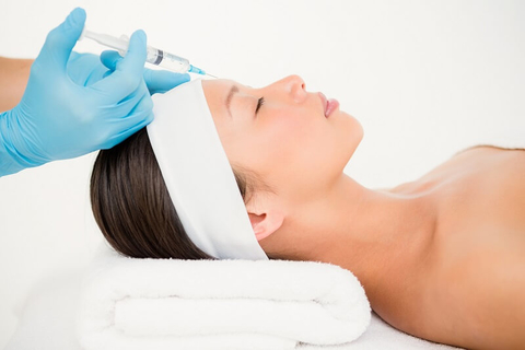 Woman receiving Botox injection on her forehead. Woman receiving Botox injection on her forehead.