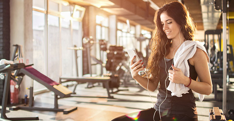 635741104 Woman on Mobile Phone in Gym