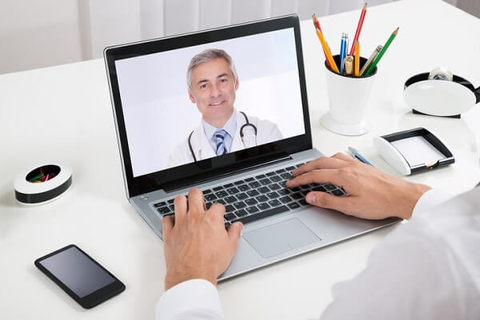 telehealth computer screen patient doctor (Getty/AndreyPopov) Businessman video-chats with doctor on laptop