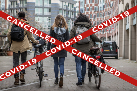 COVID-19 cancelled sign COVID-19 cancelled sign with young people walking