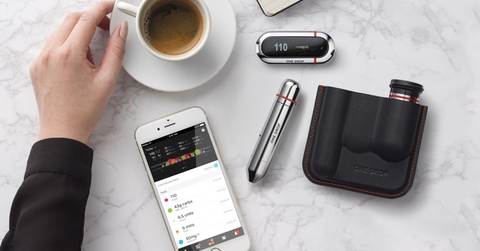One Drop kit Bird's eye view of One Drop app, lancet, blood sugar meter with a cup of coffee