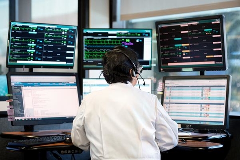 Philips tele-critical care system A doctor in a white coat sits in front of several computer screens as part of a remote critical care system