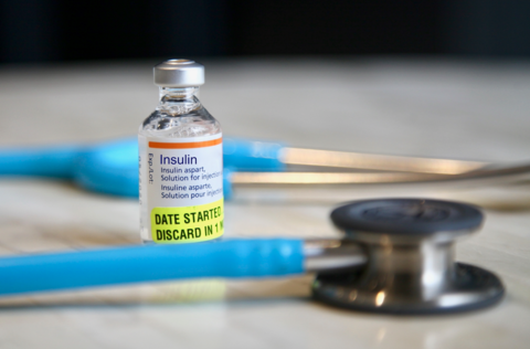 Insulin A bottle of insulin surrounded by a stethescope