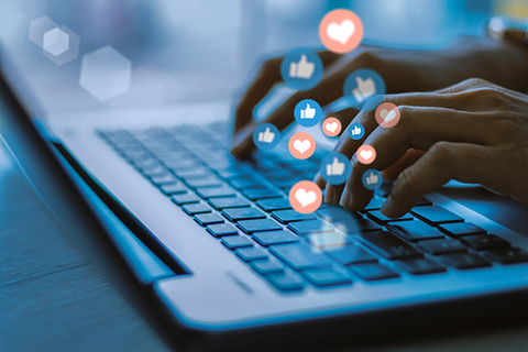 person on laptop with social media likes and shares person on laptop with social media likes and shares