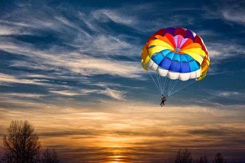 People are gliding with a parachute on the background of sunset Parachute