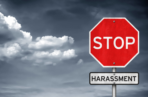 Stop sign with harassment sign underneath