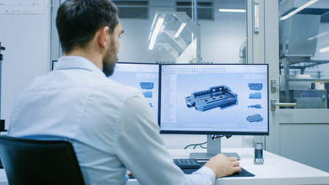 Engineer at desk with CAD drawing Engineer at desk with CAD drawing