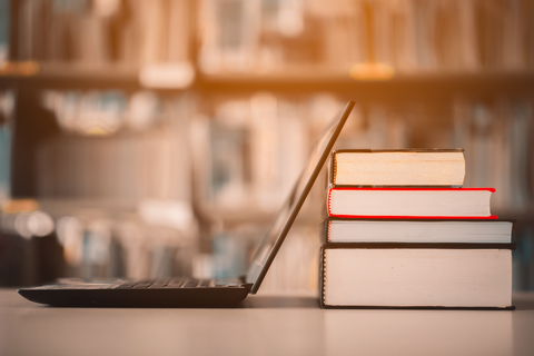 Online resources Books and laptop on library desk