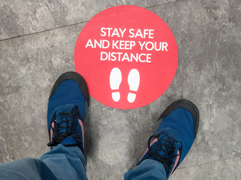 Social distancing sign with two feet Social distancing sign with two feet standing on it