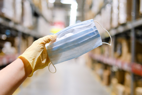 Warehouse scene with hand holding mask Warehouse scene with hand holding mask