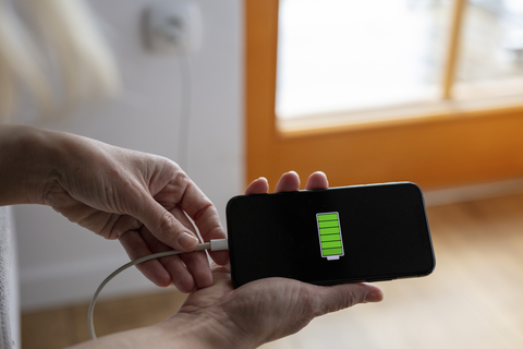 Cell phone with fully charged battery Hands holding smart phone with fully charged battery icon