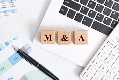 mergers and acquisitions M&A concept - M&A word made with wooden blocks on laptop