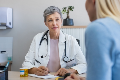 A mature woman physician consulting with a patient in the doctor's office. 