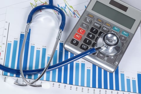Medical costs Stethoscope and calculator over graph