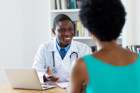 doctor consulting with patient doctor sitting at desk consulting with patient