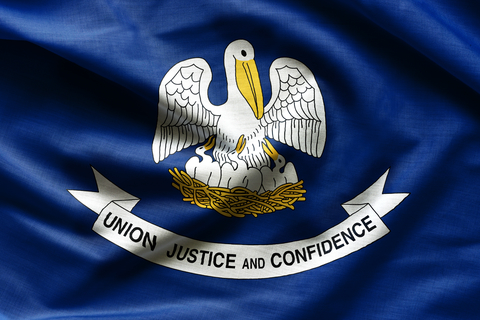 Louisiana flag Flag of Louisiana, which contains a pelican mother and three baby pelicans on a blue background with a white ribbon that says "Union Justice Confidence"