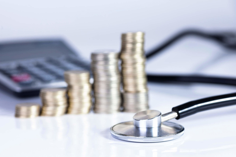 Healthcare costs finance stethoscope, coins and calculator