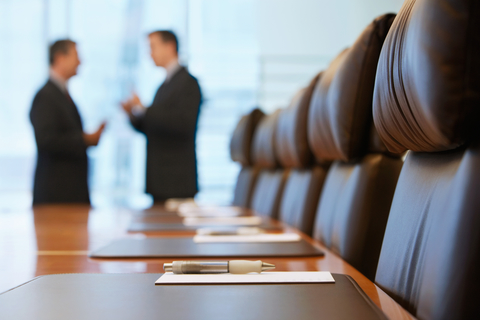 Executive business meeting Two blurred executives talk in a conference room