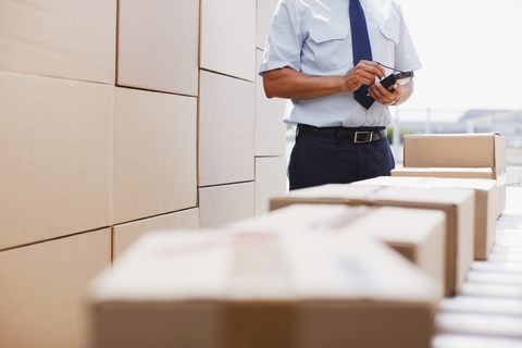 Supply chain Man checking boxes on a conveyor belt