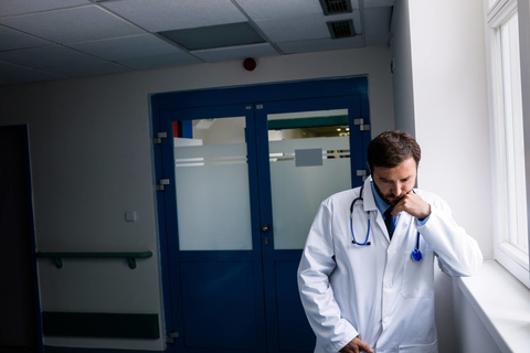 Doctor burnout Doctor pausing with a frown on his face