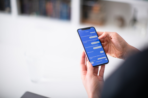 K Health app a consumer holds a smartphone and screen shot shows K Health's symptom checker app