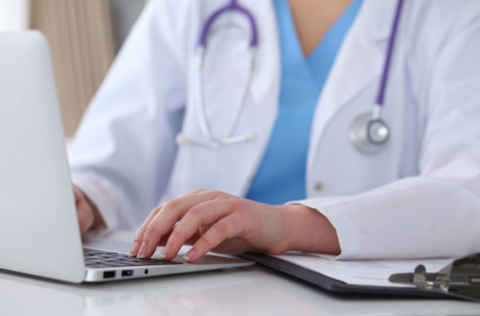 Doctor on a computer A doctor types on a computer