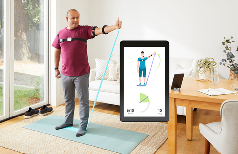 Hinge Health patient performs at-home physical therapy and smartphone screen shows virtual therapy