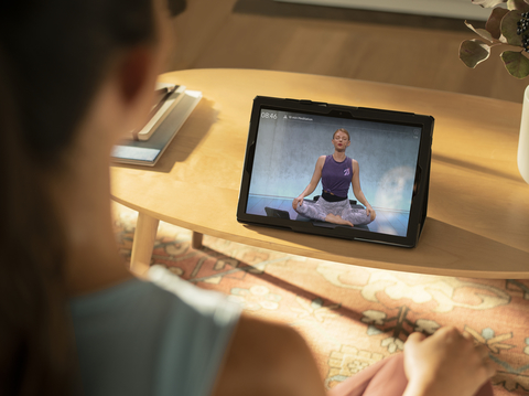 Peloton app woman doing meditation exercises with laptop screen showing Peloton app