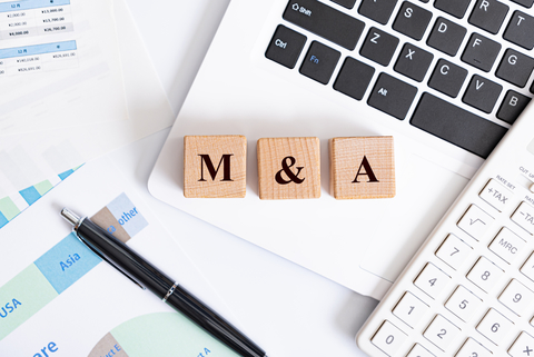 mergers and acquisitions M&A concept - M&A word made with wooden blocks on laptop