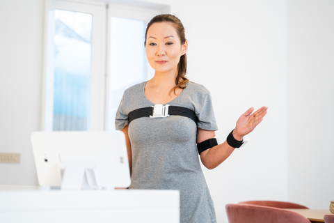 Sword Health virtual MSK care a woman stands in front of a computer screen using a virtual physical therapy program
