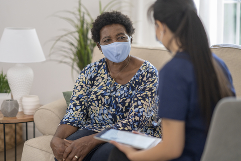 Home care A provider speaking with a patient at home with a tablet