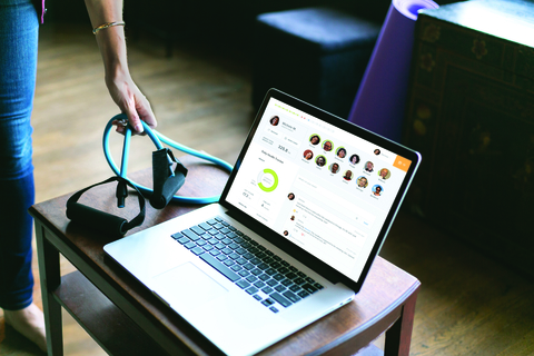 Omada Health laptop on table with screen shot of Omada Health platform with fitness equipemnt on the table