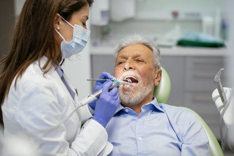 An elderly man is treated at the dentist
