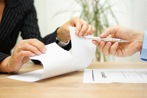 Torn contract Woman tears agreement documents in front of agent