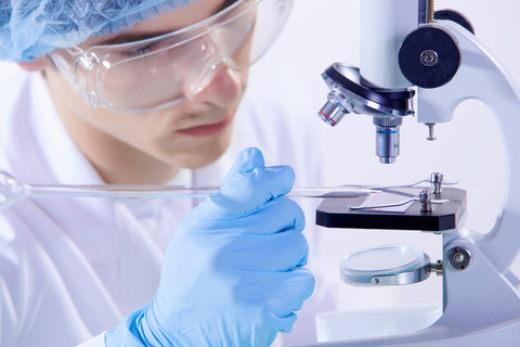 Medical research A medical researcher conducting an experiment using a microscope