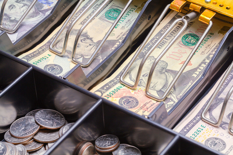 Cash drawer full of bills and coins Cash register full of money