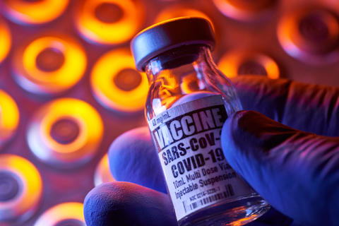 COVID-19 vaccine - Medical injection vials: hand holding, close-up and colorful - stock photo COVID-19 Vaccine/Getty Images