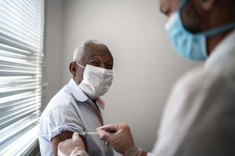 Vaccine A nurse administers a vaccine into a man's arm