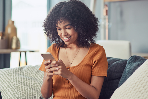 patient engagement a young woman using a smartphone on the sofa at home