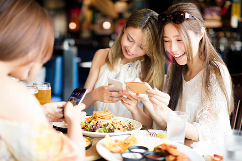 Millennial food trends Two women taking pictures of their food