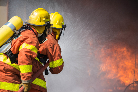 Firefighters Firefighters training a hose on a fire