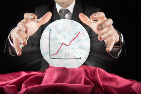 Businessman uses a crystal ball with a graph in it Businessman uses a crystal ball