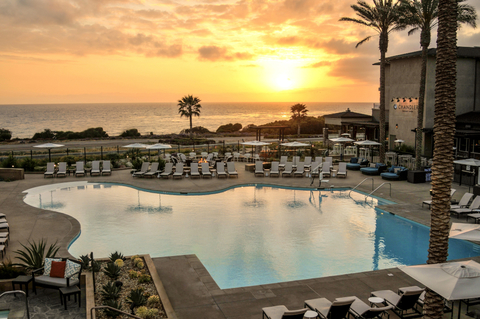 Cape Rey Carlsbad Beach, a Hilton Resort and Spa The pool area with the sun setting over the ocean in the background