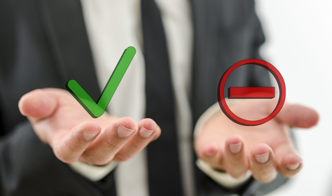 Businessman with positive and negative symbols in hand Businessman with positive and negative symbols in hand